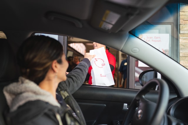 usuario recibe pedido en drive thru administrado por point software punto de venta para restaurantes de comida rapida