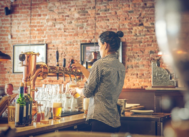 persona sirviendo una cerveza en un bar administrado con point el mejor software punto de venta para bar